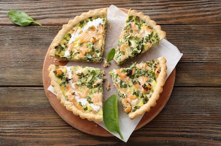 quiche with trout and spinach on wooden boards
