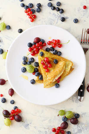 Summer crepe with berries on white plate. Food aboveの写真素材