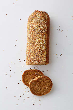 Cereal bread on white wood background. Food above