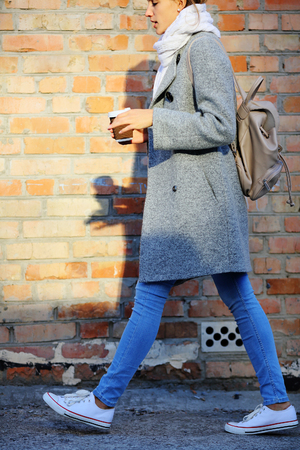 Girl runs near wall with coffeeの写真素材