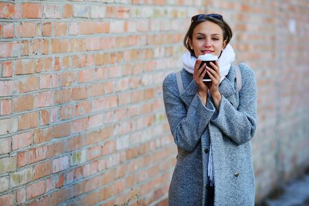 Young woman is holding warming coffee