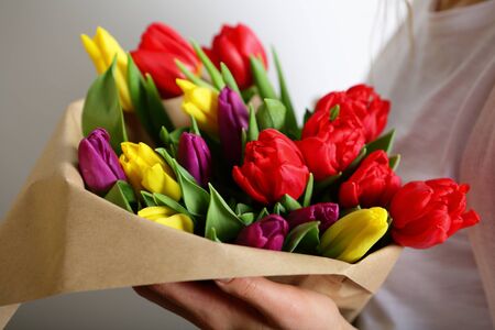 Beautiful bouquet of bright tulips flowers in female hands. Gentle photo, the concept of 8 Marchの写真素材