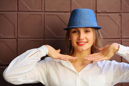 Smilling woman in blue hat hand near faceの写真素材