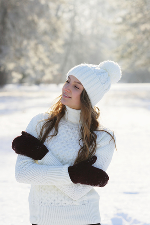 Young beautiful woman standing on the street in winter park, lifestyleの写真素材