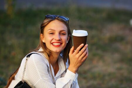 Happy young woman with coffeeの写真素材
