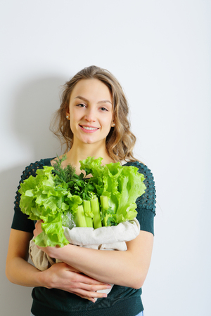Healthy young female holding a bag of greens and salad leavisの写真素材