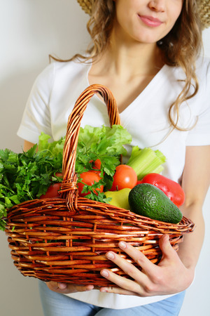 Organic healthy food in the basket, summer crop in female handsの写真素材