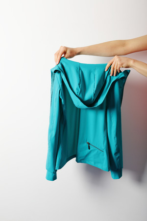 Female hands are holding a sports jacket on white backgroundの写真素材