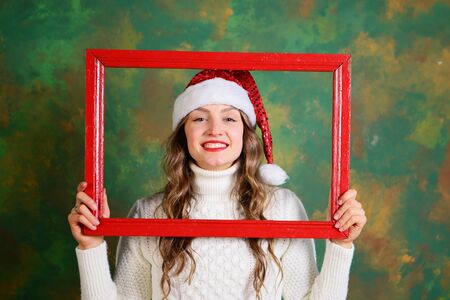 Christmas woman smiling and holding a red frameの写真素材