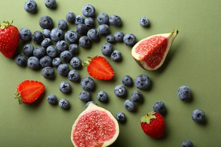 Fresh berries and fruits on green background, food aboveの写真素材