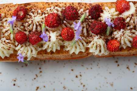 French eclair with cream and strawberry, food above