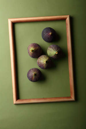 Figs in frame on green background, food concept