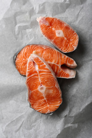 Raw salmon steaks on baking paper, food flat layの写真素材