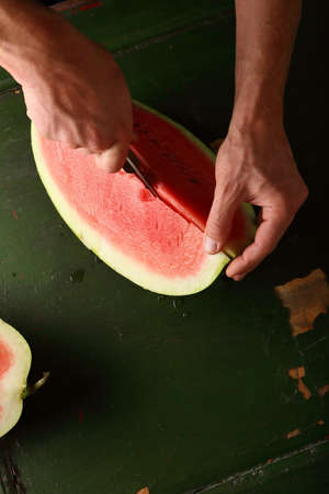 Watermelon slice in chef's hands, food closeupの写真素材