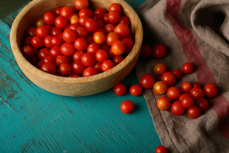 Small cherry tomatoes in wood bowl, food closeupの写真素材