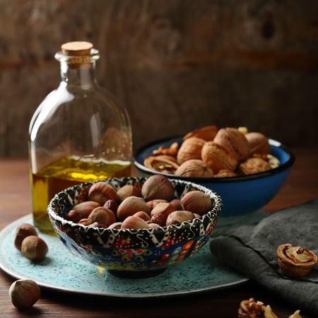Nuts in bowl and oil in bottle, healthy foodの写真素材