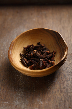 Cloves spice in wooden bowlの写真素材