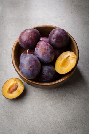 Fresh plums in wooden bowlの写真素材