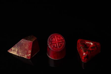 Three red candy on dark background