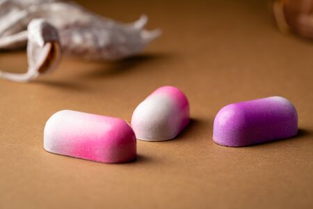 Three chocolate candies on brown background