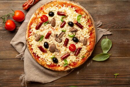 Pizza with sausage and mushrooms top view on woodの写真素材