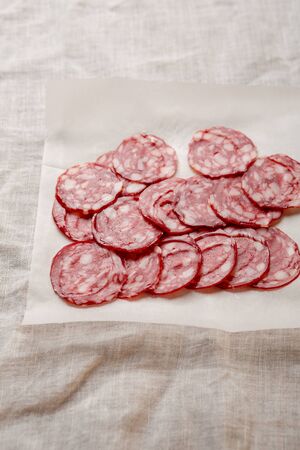 Sliced pork salami on white paperの写真素材