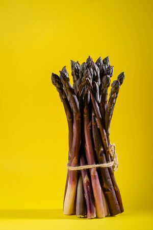 Bunch of fresh asparagus, food on yellowの写真素材