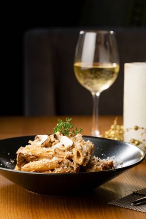 Penne pasta with mushrooms sauce close-up and wineの写真素材