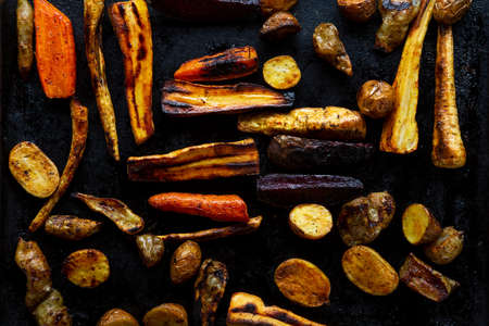 Overhead view of roasted vegetables on black surfaceの写真素材