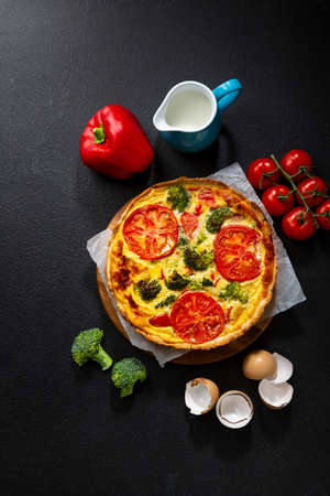 Quiche lorraine with broccoli and cheese on  dark background, overhead viewの写真素材