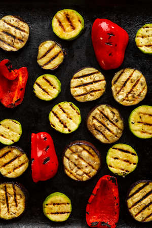 Food pattern with grilled sliced vegetables, vegan food on black surfaceの写真素材