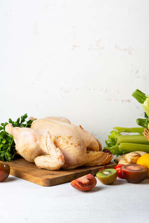 Whole raw chicken on kitchen board, cooking conceptの写真素材