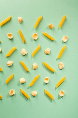 Raw pasta pattern on green surfaceの写真素材