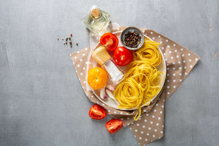 Raw various pasta and tomatoes overhead viewの写真素材