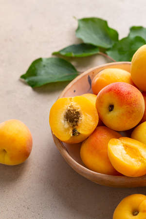 Close up of Raw ripe apricots in bowl on stone tableの写真素材