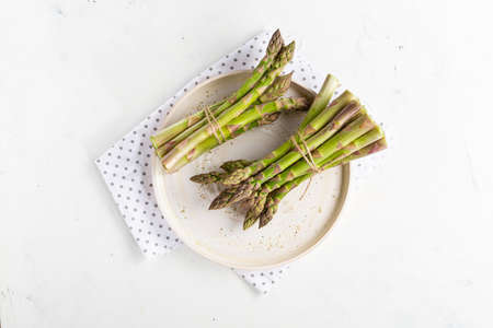 Two bunches of asparagus on white plateの写真素材