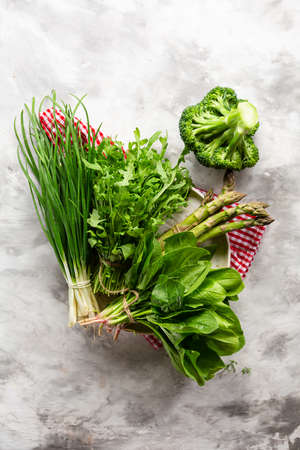 Overhead view of Green leaf spring vegetables on light surfaceの写真素材