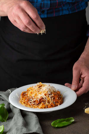Chef serving pasta in white plateの写真素材