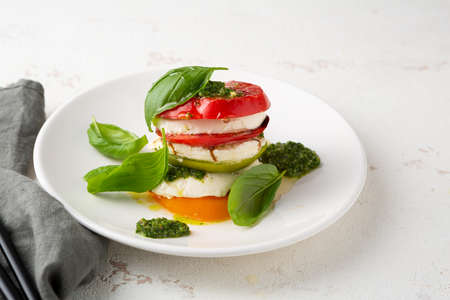 Summer caprese salad on white plateの写真素材