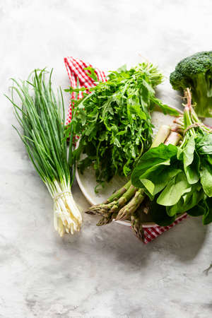 Green leaf spring vegetables on white plateの写真素材
