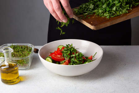 Large salad bowlon white table, cooking at homeの写真素材