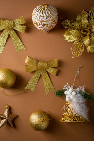 Overhead view of golden Christmas decorations on brown surfaceの写真素材