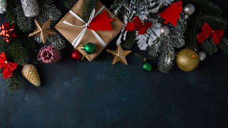 Christmas decoration, gift box, branches top view on dark surfaceの写真素材