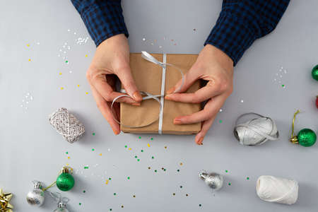 Preparing Christmas gift box from above, paper craft and handsの写真素材