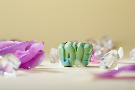 Green love shape candies on beige surfaceの写真素材