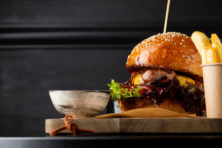 Delicious grilled burger with  bacon close up on dark tableの写真素材