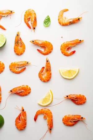 Overhead view of shrimps and lemon on light surfaceの写真素材