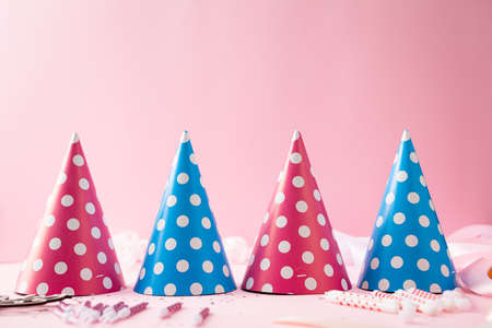 Pink birthday greeting card background with party hats and copy spaceの写真素材