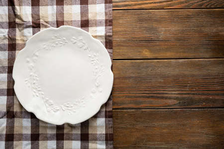 Overhead view of empty white plate on wooden tableの写真素材