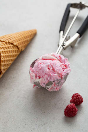 Close up of strawberries ice cream scoop on spoon, summer food